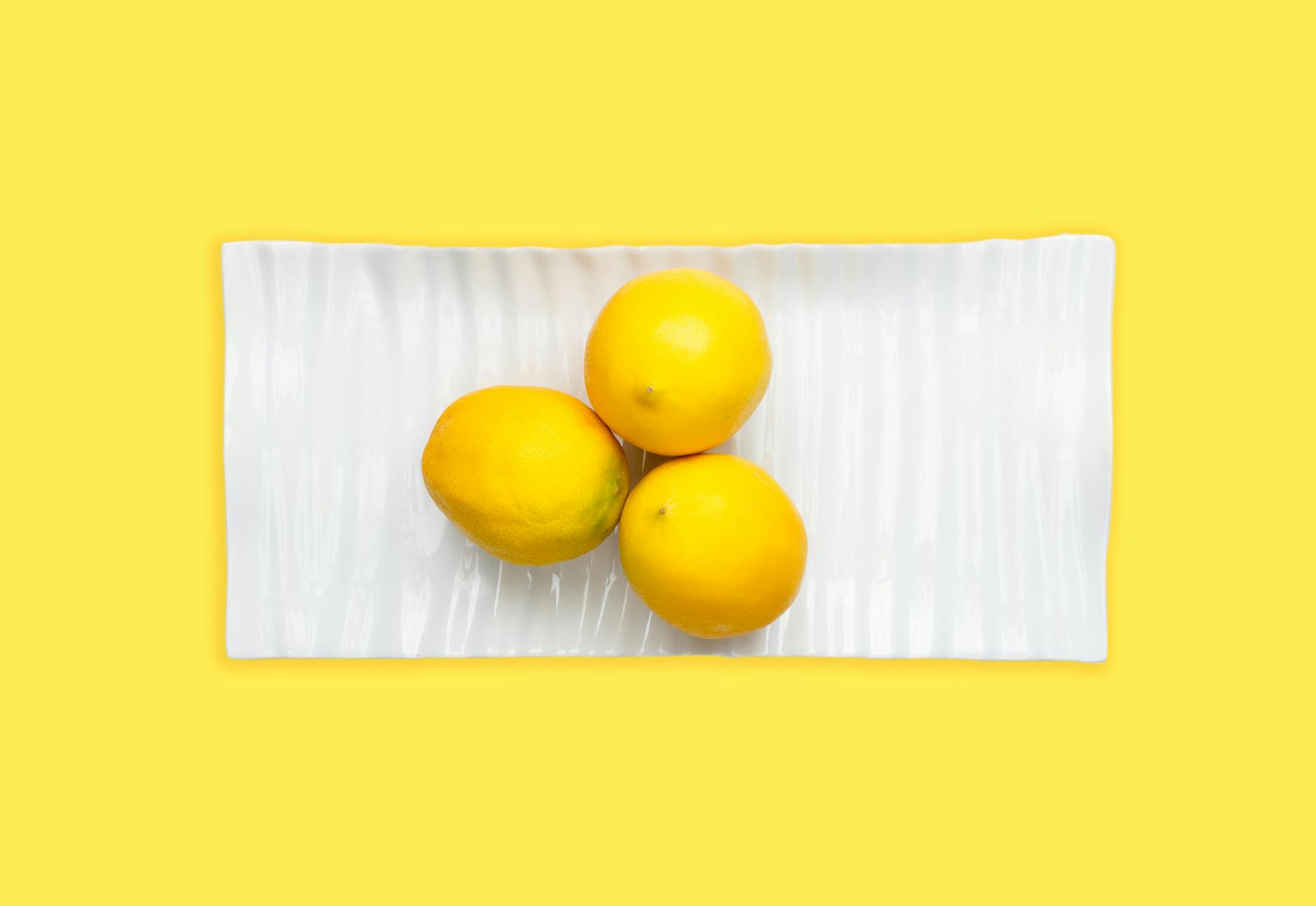 Hand holding an orange vibrator against a minimalistic backdrop, symbolizing reclamation of personal pleasure and self-intimacy.