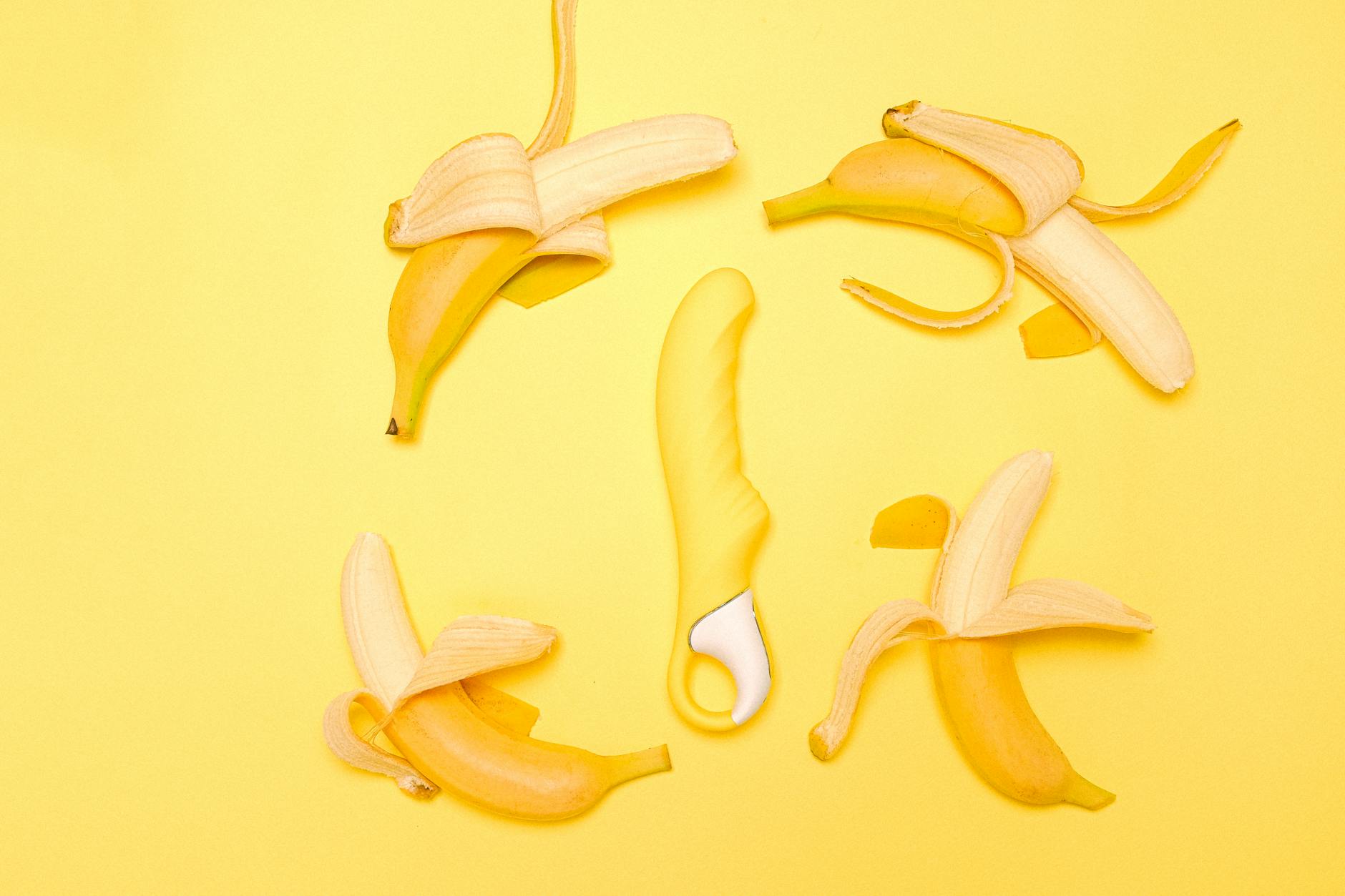 Vibromasseur citron jaune entouré de fruits jaunes sur fond jaune, représentant le plaisir et la sensualité