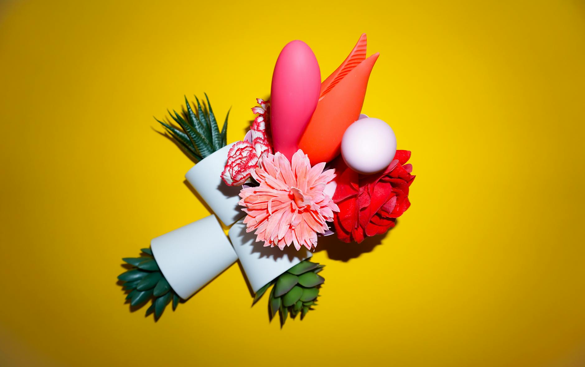Colorful arrangement of vibrators and flowers on a bright background, representing renewed confidence and pleasure